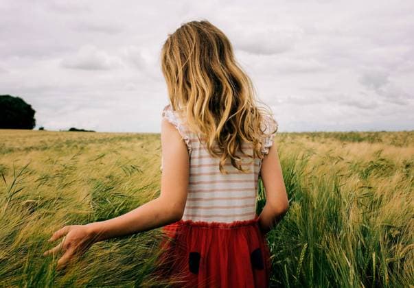 Creative Highlights Symbolbilder girl walking through a corn field feeling the grass on a cloudy day Winchester, England, United Kingdom CR_RABE2207118D-1006305-01 ,model released, Symbolfoto