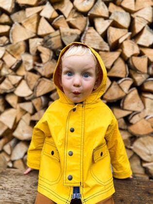 Creative Highlights Symbolbilder Toddler with a surprised face on the background of firewood. Ivano-Frankivsk, Ivano-Frankivsk Oblast, Ukraine CR_VZYA22071362-1007550-01 ,model released, Symbolfoto