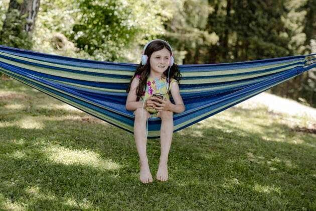 Creative Highlights Symbolbilder Mädchen, 8 Jahre, sitzt in einer Hängematte im Schatten und hört mit Kopfhörer Musik *** Girl, 8 Years, sits in a Hammock at Shadows and listens to with Headphones Music Copyright: imageBROKER MichaelaxBegsteiger ibxbeg08378359.jpg ,model released, Symbolfoto ,property released