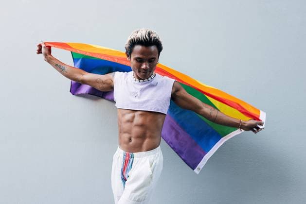 Creative Highlights Symbolbilder Stylish guy dancing with rainbow flag outdoors Copyright: xArtemxVarnitsinxArtemxVarnitsinx