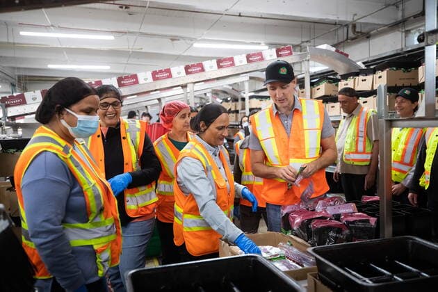 July 18, 2022, KELOWNA, BC, CANADA: Prime Minister Justin Trudeau helps workers prepare bags to pack cherries during a visit to the B.C. Fruit Growers packing plant in Kelowna, B.C., on Monday, July 18, 2022. KELOWNA CANADA  - ZUMAc35_ 20220718_zaf_c35_049 Copyright: xDarrylxDyckx