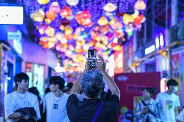 (220723) -- GUIYANG, July 23, 2022 -- A visitor takes photos of a local market at the Qingyun Road in Nanming District of Guiyang, capital city of southwest China s Guizhou Province, July 21, 2022. Qingyun Road was a famous bustling food street at nighttime in the city of Guiyang. Thanks to local planning and years of renovation, the road has turned to be a popular commercial pedestrian street which contains various trendy businesses like cultural innovation and art design while retaining its food street fame. ) CHINA-GUIZHOU-GUIYANG-NIGHT ECONOMY (CN) YangxWenbin 