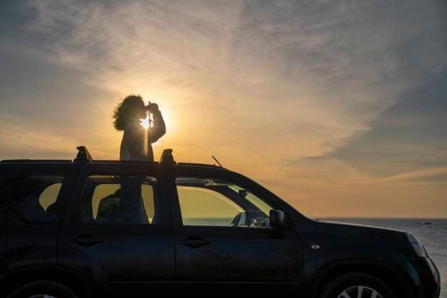 IMAGO Creative: Welttourismustag am 27. September Woman looking through binoculars at sunset model released, Symbolfoto, VPIF06364