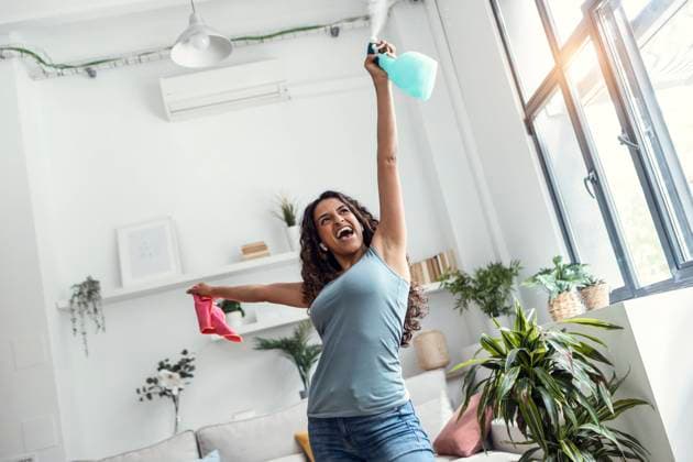 Happy woman cleaning home spraying water from bottle model released, Symbolfoto property released, JSRF02103