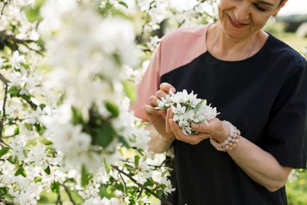 IMAGO Creative, Frühling, Start der Garten-Saison IMAGO Creative: Jahreszeit Frühling, Frühlingsanfang am 20. März Smiling woman holding white flowers model released, Symbolfoto, LLUF00683