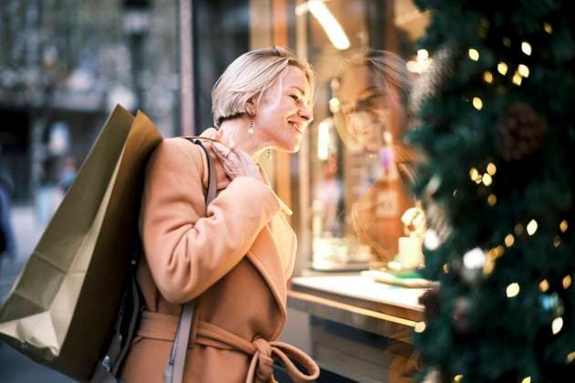 Beautiful woman with shopping bag looking through window of store model released, Symbolfoto, AGOF00280