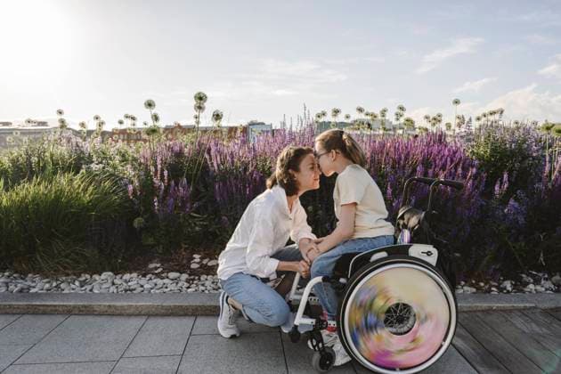 Daughter in wheelchair kissing mother at park model released, Symbolfoto, EYAF01984
