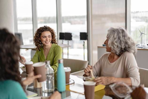 Happy senior businesswoman having snacks with coworkers model released, Symbolfoto property released, JCICF00150
