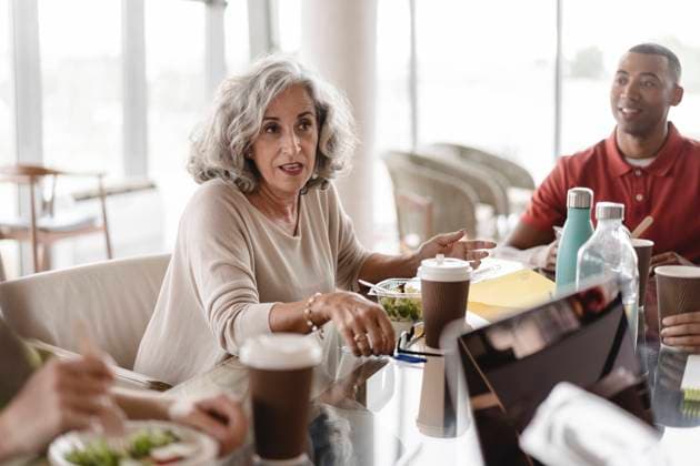 Senior businesswoman sitting with businessman discussing at table in office model released, Symbolfoto property released, JCICF00151