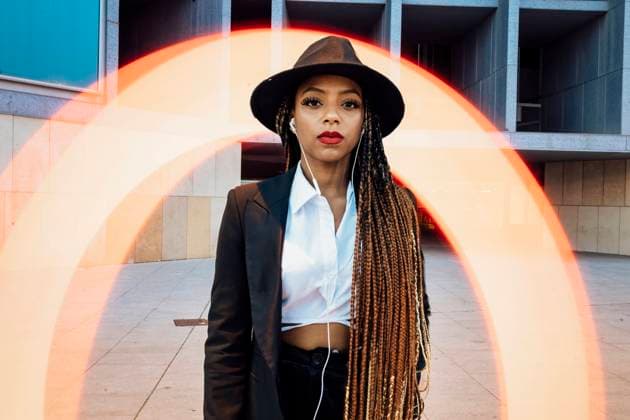 Young businesswoman standing in front of orange semi-circle light painting model released, Symbolfoto, JRVF03033