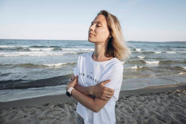 Smiling woman with arms crossed standing in front of sea model released, Symbolfoto, SIF00232