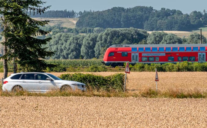 IMAGO Creative: Gesellschaft, Mobilität auf dem Land Auto und Regionalzug auf dem Land, unterwegs im Landkreis Landshut, Niederbayern, Juli 2022 Deutschland, Nähe Landshut, 23. Juli 2022, Auto und Regionalzug auf dem Land, PKW unterwegs in Niederbayern, Landkreis Landshut, fährt in Richtung Dingolfing, Regionalzug der Bahn fährt in Richtung Landshut, Symbolfoto Konkurrenz Schiene - Strasse, Wettbewerb zwischen PKW oder Bahn, Deutsche Bahn, Fahrtkosten, Kosten, was ist günstiger, billiger, Verkehrswende, 9-Euro-Ticket, Pendler, Pendlerpauschale, Autofahrt, Bahnfahrt, Verkehr, Regionalverkehr, Sommer, flirrende Hitze, Sommerhitze, über 30 Grad Celsius, Rekordhitze, Wetter, Bayern, Juli 2022, Querformat, *** Car and regional train in the countryside, on the road in the district of Landshut,