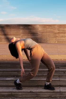 Creative Highlights Symbolbilder Full body of active female in sportswear bending back while warming up before training on stairs during outdoor workout in city, Model released AlfonsoSaenz_Stretching_33.jpg Copyright: xAlfonsoxSaenzx MR