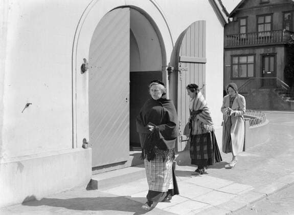 Poll photo collection. Iceland. Reykjavik. Kerkgangs, two of whom in traditional clothing, at the Zuiderportal of the Domkerk. 1934. Iceland, Reykjavik Copyright: xpiemagsx pienatarchpart630102021-18724 !ACHTUNG AUFNAHMEDATUM GESCHÄTZT!
