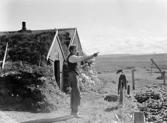 Poll photo collection. Iceland. Man partly covered with grass sods and walls of stacked stones at a simple farmhouse. 1934. Iceland Copyright: xpiemagsx pienatarchpart630102021-18726 !ACHTUNG AUFNAHMEDATUM GESCHÄTZT!