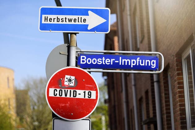 FOTOMONTAGE, StraÃŸenschilder mit den Aufschriften Covid-19, Herbstwelle und Booster-Impfung