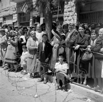 Poll photo collection. Israel 1948-1949: Jerusalem. Jerusalem. Audience behind barbed wire at the parade on the occasion of the first commemoration of Israels independence on May 15, 1949. On the right women, one with tambourine, from Bukhara, a city in today s Uzbekistan, in national clothing. May 15, 1949. Buchanan, Israel, Jerusalem Copyright: xpiemagsx pienatarchpart630102021-33401 !ACHTUNG AUFNAHMEDATUM GESCHÄTZT!