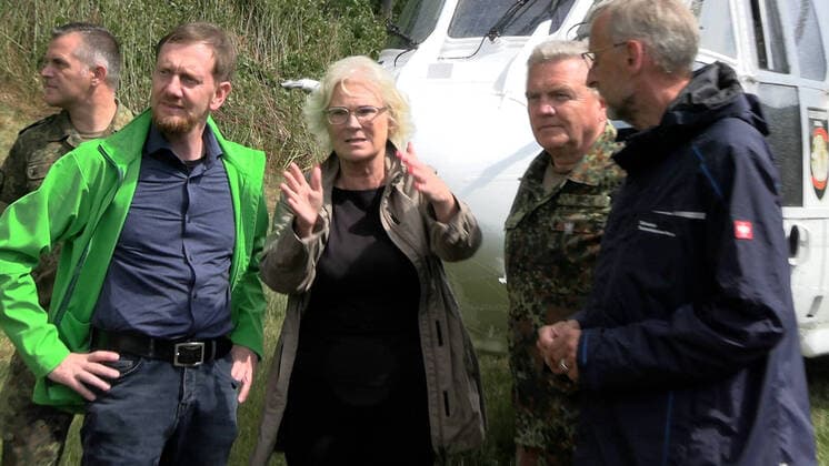 Bilder des Jahres 2022, News 08 August News Themen der Woche KW31 News Bilder des Tages ID 638 Gegen 14 Uhr trafen Ministerpräsident Michael Kretzschmer, Innenminister Armin Schuster an der Einsatzleitung in Bad Schandau ein. Sie sprachen mit Kameraden und Anwohnern, sowie das Erlebte der letzten Tage. Ein Feuerwehrkamerad schildert, wie anstrengend der Einsatz sei. Am Grenzübergang in Schmilka landete derweil die Verteidigungsministerin Christine Lambrecht. Sie wurde von der Bundeswehr empfangen und bestaunte die Arbeit der Bundeswehr, bevor sie zur Einsatzleitung fuhr. Der intensive Löscheinsatz von der Luft und Boden hält auch am Montag weiter an. Zahlreiche Hubschrauber kreisen über der Elbe und holen Löschwasser. Mittlerweile wurde die Taktik geändert. Netzmittel und Löschschaum sollen zum Einsatz kommen. Hierzu wird in
