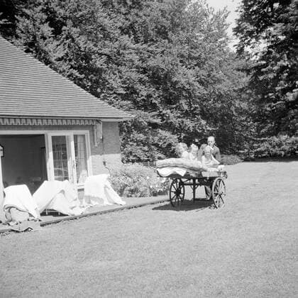 Poll photo collection. The royal family at Soestdijk Palace. The Princesses Beatrix, Irene and Marguerite on a handcart at the summer house with a staff member. July 1947. Baarn, Utrecht (province) Copyright: xpiemagsx pienatarchpart72010201-16191 !ACHTUNG AUFNAHMEDATUM GESCHÄTZT!