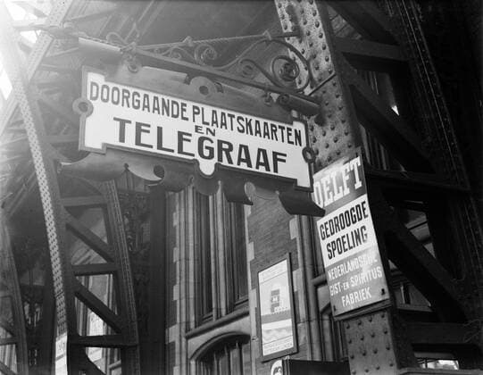 Poll photo collection. Reporting Dutch Railways. Signs on the platform of Central Station: links a sign referring to the locator for main place cards and telegraph, on the right a billboard from the Dutch yeast and Spiritus factory Delft . 1932. Amsterdam, Noord-Holland Copyright: xpiemagsx pienatarchpart72010201-45316 !ACHTUNG AUFNAHMEDATUM GESCHÄTZT!
