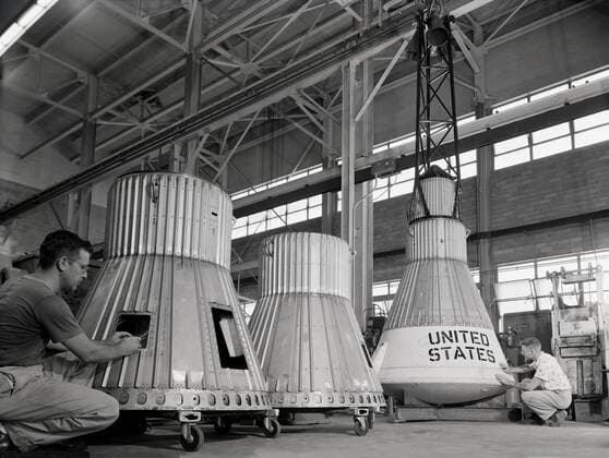 Assembling the Little Joe capsules. The capsules were manufactured in-house by Langley technicians. Three capsules are shown here in various stages of assembly. The escape tower and rocket motors shown on the completed capsule would be removed before shipping and finally assembly for launching at Wallops Island. Joseph Shortal wrote (vol. 3, p. 32): Design of the Little Joe capsules began at Langley before McDonnell started on the design of the Mercury capsule and was, therefore, a separate design. Although it was not designed to carry a man, it did have to carry a monkey. It had to meet the weight and center of gravity requirements of Mercury and withstand the same aerodynamic loads during the exit trajectory. Although in comparison Copyright: xpiemagsx piemagsspace-660 !ACHTUNG AUFNAHMEDATUM GESCHÄTZT!