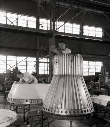 Assembling the Little Joe capsules. The capsules were manufactured in-house by Langley technicians. Three capsules are shown here in various stages of assembly. The escape tower and rocket motors shown on the completed capsule would be removed before shipping and finally assembly for launching at Wallops Island. Joseph Shortal wrote (vol. 3, p. 32): Design of the Little Joe capsules began at Langley before McDonnell started on the design of the Mercury capsule and was, therefore, a separate design. Although it was not designed to carry a man, it did have to carry a monkey. It had to meet the weight and center of gravity requirements of Mercury and withstand the same aerodynamic loads during the exit trajectory. Although in comparison Copyright: xpiemagsx piemagsspace-661 !ACHTUNG AUFNAHMEDATUM GESCHÄTZT!