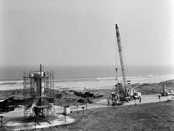 Technicians attach the escape tower to the Mercury capsule prior to assembly with Little Joe launcher, August 20, 1959. Joseph Shortal describe this as follows (vol. 3., p. 33): The escape tower and rocket motors were taken from the Mercury capsule production. The tower is shown being attached to the capsule.... The escape rocket was a Grand Central 1-KS-52000 motor with three canted nozzles. The tower-jettison motor was an Atlantic Research Corp. 1.4-KS-785 motor. This was the same design tested in a beach abort test...and had the offset thrust line as used in the beach abort test to insure that the capsule would get away from the booster in an emergency. The escape system weighed 1,015 pounds, including 236 pounds of ballast for stabili Copyright: xpiemagsx piemagsspace-677 !ACHTUNG AUFNAHMEDATUM GESCHÄTZT!