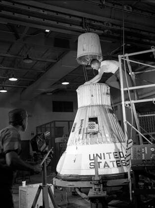 Technicians adjust the rocket motor during the attachment of the escape tower to the Mercury capsule prior to assembly with Little Joe launcher, August 20, 1959. Joseph Shortal wrote (vol. 3., p. 33): The escape tower and rocket motors were taken from the Mercury capsule production. The tower is shown being attached to the capsule.... The escape rocket was a Grand Central 1-KS-52000 motor with three canted nozzles. The tower-jettison motor was an Atlantic Research Corp. 1.4-KS-785 motor. This was the same design tested in a beach abort test...and had the offset thrust line as used in the beach abort test to insure that the capsule would get away from the booster in an emergency. The escape system weighed 1,015 pounds, including 236 pounds Copyright: xpiemagsx piemagsspace-681 !ACHTUNG AUFNAHMEDATUM GESCHÄTZT!