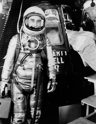 S61-02888 (1961) --- Astronaut Virgil I. (Gus) Grissom, suited up and ready to climb into Liberty Bell 7 spacecraft, stands in front of the capsule for a picture. Backup pilot John Glenn is in the right corner of the view behind Grissom. The Mercury-Redstone 4 (MR-4) mission was scrubbed a few hours later due to unfavorable weather over the launch pad. Copyright: xpiemagsx piemagsspace-867 !ACHTUNG AUFNAHMEDATUM GESCHÄTZT!