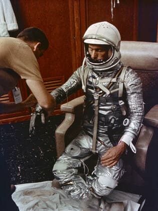 S64-14870 (May 1962) --- Astronaut M. Scott Carpenter, prime pilot for the Mercury-Atlas 7 (MA-7) flight, is seen in Hanger S crew quarters during a preflight suiting activity at Cape Canaveral, Florida. He is assisted in suiting by technician Al Rochford. In this view, Carpenter is fully suited and is having his gloves adjusted. Copyright: xpiemagsx piemagsspace-958 !ACHTUNG AUFNAHMEDATUM GESCHÄTZT!