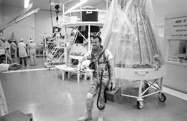 S63-03966 (1963) --- Astronaut L. Gordon Cooper Jr., prime pilot for the Mercury-Atlas 9 (MA-9) mission, carrying the portable air conditioner to his spacesuit, leaves Hanger S after completing the day s simulated flight tests. Copyright: xpiemagsx piemagsspace-1030 !ACHTUNG AUFNAHMEDATUM GESCHÄTZT!
