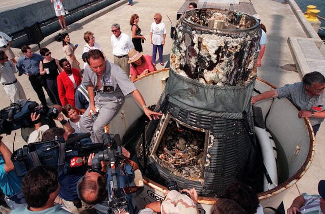 KENNEDY SPACE CENTER, FLA. -- Retrieved from the ocean floor three miles deep, the Liberty Bell 7 Project Mercury capsule is revealed to photographers and the media in Port Canaveral, Fla. The capsule was found and raised by Curt Newport (left), leading an expedition sponsored by the Discovery Channel. After its successful 16-minute suborbital flight on July 21, 1961, the Liberty Bell 7, with astronaut Virgil Gus Grissom aboard, splashed down in the Atlantic Ocean. A prematurely jettisoned hatch caused the capsule to flood and a Marine rescue helicopter was unable to lift it. It quickly sank to a three-mile depth. Grissom was rescued but his spacecraft remained lost on the ocean floor, until now. An underwater salvage expert, Newport Copyright: xpiemagsx piemagsspace-10579 !ACHTUNG AUFNAHMEDATUM GESCHÄTZT!