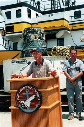 KENNEDY SPACE CENTER, FLA. -- Gunther Wendt takes a turn at the podium after viewing the recovered Liberty Bell 7 Project Mercury capsule, seen in the background. At right is Curt Newport who led the expedition to find and retrieve the capsule. The expedition was sponsored by the Discovery Channel. Wendt worked on the Liberty Bell 7 before its launch July 21, 1961. After its successful 16-minute suborbital flight, the Liberty Bell 7, with astronaut Virgil Gus Grissom aboard, splashed down in the Atlantic Ocean. A prematurely jettisoned hatch caused the capsule to flood and a Marine rescue helicopter was unable to lift it. It quickly sank to a three-mile depth. Grissom was rescued but his spacecraft remained lost on the ocean floor, Copyright: xpiemagsx piemagsspace-10580 !ACHTUNG AUFNAHMEDATUM GESCHÄTZT!