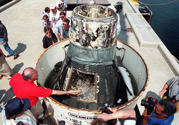KENNEDY SPACE CENTER, FLA. -- Media and spectators get a close-up view of the Liberty Bell 7 Project Mercury capsule after its recovery from the Atlantic Ocean floor where it lay for 38 years. Launched July 21, 1961, the capsule made a successful 16-minute suborbital flight, with astronaut Virgil Gus Grissom aboard, and splashed down in the Atlantic Ocean. A prematurely jettisoned hatch caused the capsule to flood and a Marine rescue helicopter was unable to lift it. It quickly sank to a three-mile depth. Grissom was rescued but his spacecraft remained lost on the ocean floor, until now. Curt Newport, an underwater salvage expert, located the capsule through modern technology, and after one abortive attempt, successfully raised it an Copyright: xpiemagsx piemagsspace-10581 !ACHTUNG AUFNAHMEDATUM GESCHÄTZT!