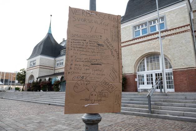 Punker-Camp in Westerland 04.08.2022, Westerland --- Ein Schild mit Verbesserungsvorschlägen ist am Rathaus neben dem Protest-Camp von Punkern auf der Nordseeinsel Sylt an einem Lampe befestigt. Westerland Schleswig-Holstein Deutschland *** Punkers Camp in Westerland 04 08 2022, Westerland A sign with suggestions for improvement is attached to a lamp at the town hall next to the protest camp of punkers on the North Sea island of Sylt Westerland Schleswig Holstein Germany