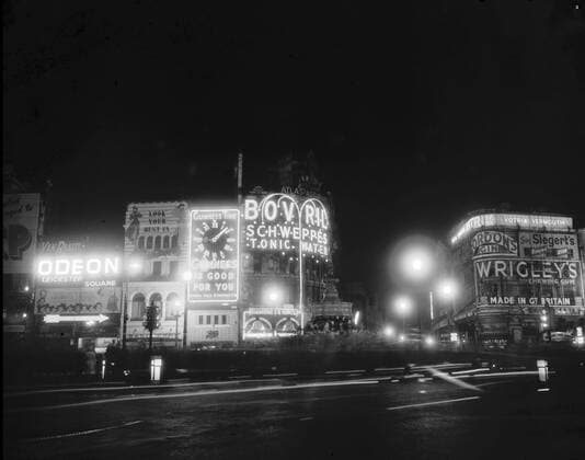 Circa 1949, London, England, United Kingdom: Piccadilly Circus with Eros in the center surrounded by flashing advertisement signs and billboards for Wrigley s chewing gum, Guinness, Bovril and Schweppes drinks. London United Kingdom - ZUMAk09_ 19490402_zka_k09_987 Copyright: xKeystonexUSAx
