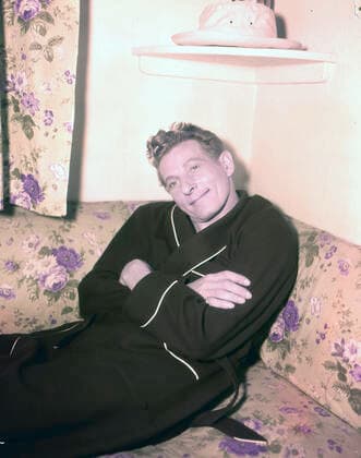 Archivbilder der Woche KW32 Circa 1965, London, England, United Kingdom: American actor DANNY KAYE sitting on a floral couch wearing a dressing gown. London United Kingdom - ZUMAk09_ 19650402_zka_k09_038 Copyright: xKeystonexUSAx