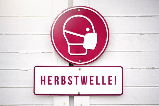 FOTOMONTAGE, Maskenpflicht-Schild und Schild mit der Aufschrift Herbstwelle