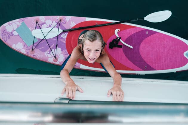 Creative Highlights Symbolbilder Top view of kid crawling on yacht from sup board. Thasos, Greece CR_IEID220816-1025293-01 ,model released, Symbolfoto