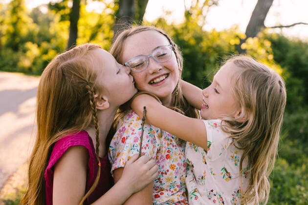 Creative Highlights Symbolbilder Young sisters laugh, hug and kiss in golden light Lindenhurst, Illinois, United States CR_WVNP220815-1026429-01 ,model released, Symbolfoto