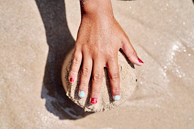 Creative Highlights Symbolbilder Child s hand with painted nails playing in the sand on the beach Chanteiro, Galicia, Spain CR_VFKDPR220815-1027187-01 ,model released, Symbolfoto