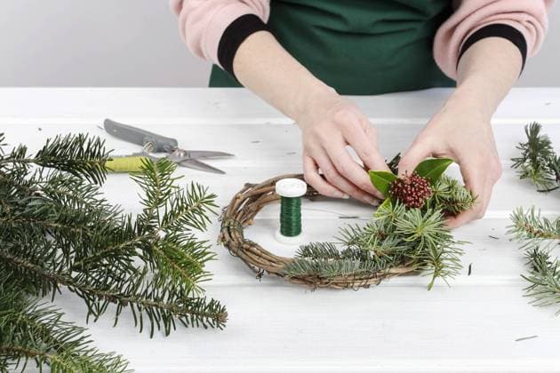 Florist at work: woman shows how to make Christmas door wreath made of fir twigs. Step by step, tutorial.  BEW1DB1CA85