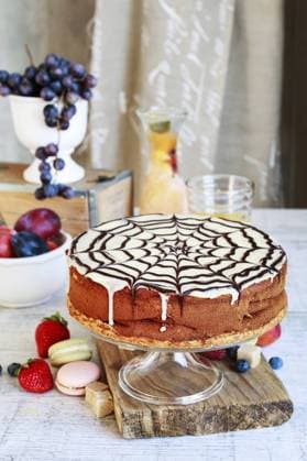 Halloween chocolate spider web cake and various fruits around. Party dessert  BEW1DBB6965
