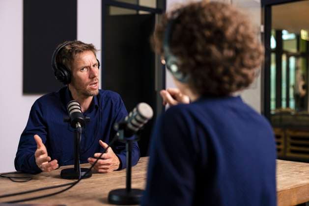 Guest gesturing talking with radio DJ in recording studio model released, Symbolfoto property released, JOSEF11160