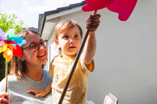 Happy mother looking at son playing with pinwheel toy model released, Symbolfoto property released, IHF01048