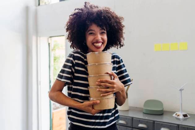 Happy businesswoman holding lunch boxes in office model released, Symbolfoto property released, MEUF07114