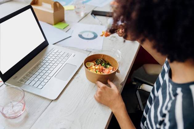 Businesswoman having poke bowl by laptop in lunch break at office model released, Symbolfoto property released, MEUF07121