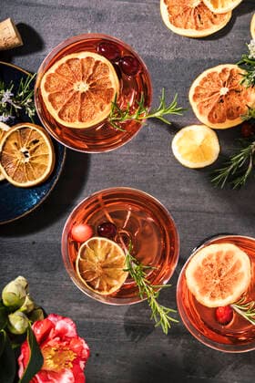 Cranberry champagne cocktails garnished with orange and rosemary, ACTF00236