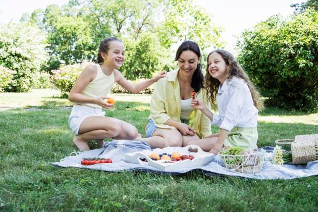 Happy daughters having picnic with mother at park on weekend model released, Symbolfoto, OSF00500