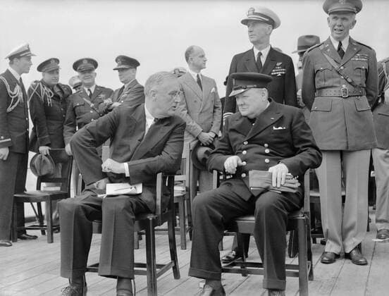 President Roosevelt and Winston Churchill seated on the quarterdeck of HMS Prince of Wales for a Sunday service during the Atlantic Conference, 10 August 1941. The President of the United States, Franklin D Roosevelt, and the Prime Minister of the United Kingdom, Winston Churchill are seated on the Quarterdeck of HMS Prince of Wales. They are chatting following a Sunday service, during the Atlantic Conference, 10 August 1941. Immediately behind them are Admiral E J King, USN and General Marshall, US Army. The President s sons, Ensign Franklin Roosevelt Jr USNR and Captain Elliot Roosevelt USAAF, along with General Arnold, USAAF, Air Chief Marshal Sir Wilfred Freeman RAF are conversing to the left of the image. Copyright: xpiemagsx admiralww2pie10322-1089 !ACHTUNG AUFNAHMEDATUM GESCHÄTZT!